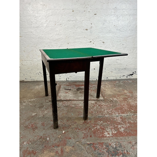 25 - A Georgian mahogany fold over games table - approx. 74cm high x 84cm wide x 42cm deep when closed