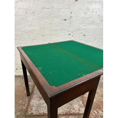 25 - A Georgian mahogany fold over games table - approx. 74cm high x 84cm wide x 42cm deep when closed