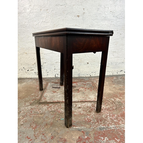 25 - A Georgian mahogany fold over games table - approx. 74cm high x 84cm wide x 42cm deep when closed