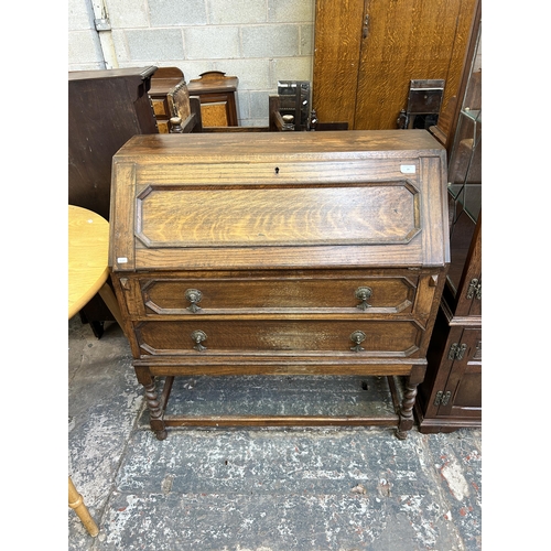 29 - An early 20th century oak bureau on barley twist supports