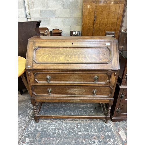 29 - An early 20th century oak bureau on barley twist supports