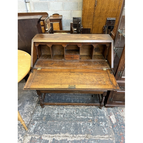 29 - An early 20th century oak bureau on barley twist supports