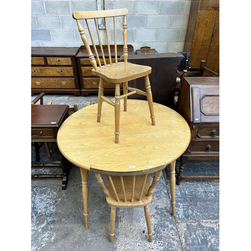 30 - A beech circular dining table and two chairs - approx. 74cm high x 106cm diameter