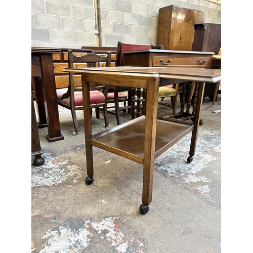 32 - A mid 20th century oak two tier tea trolley - approx. 65cm high x 64cm wide x 80cm long