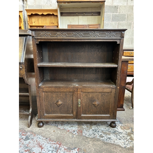 33 - A carved oak two tier bookcase - approx. 107cm high x 91 cm wide x 30cm deep