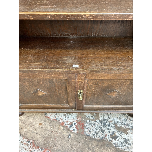 33 - A carved oak two tier bookcase - approx. 107cm high x 91 cm wide x 30cm deep