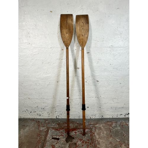 35 - A pair of mid 20th century pine and plywood boat oars - approx. 180cm long