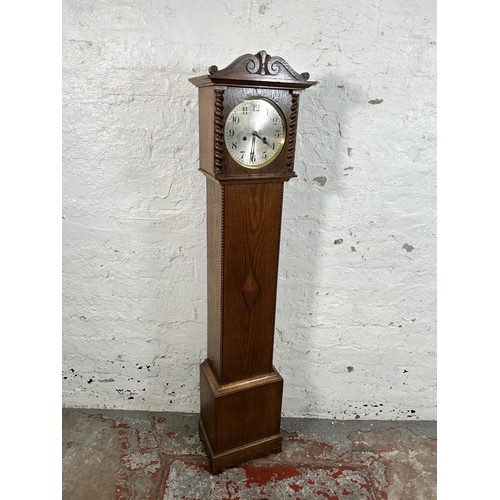 38A - A 1930s oak cased granddaughter clock with key and pendulum - approx. 136cm high