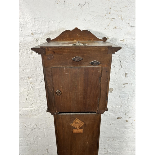 38A - A 1930s oak cased granddaughter clock with key and pendulum - approx. 136cm high