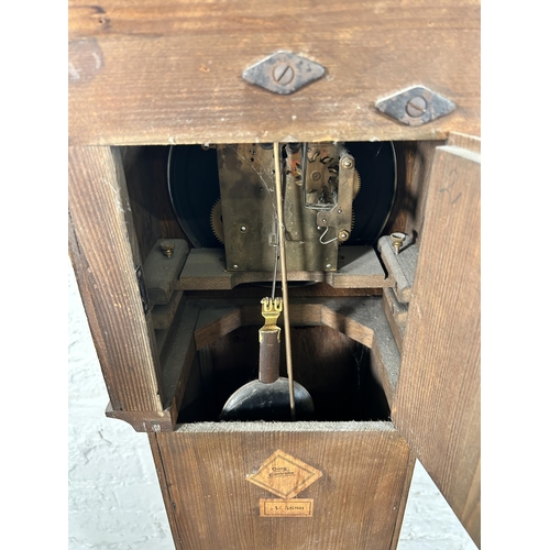 38A - A 1930s oak cased granddaughter clock with key and pendulum - approx. 136cm high