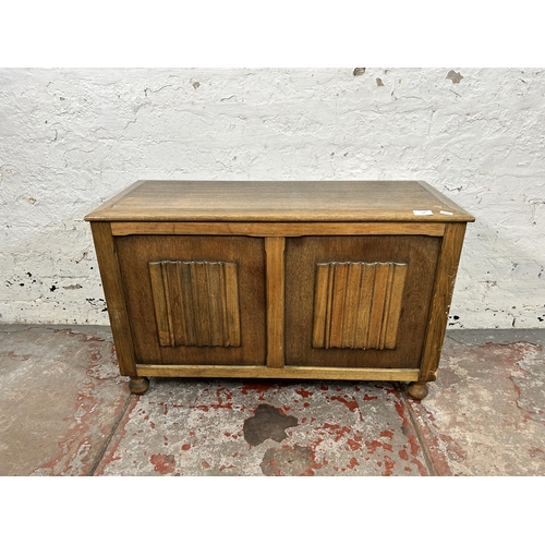 57 - A mid 20th century oak linenfold blanket box - approx. 52cm high x 82cm wide x 36cm deep