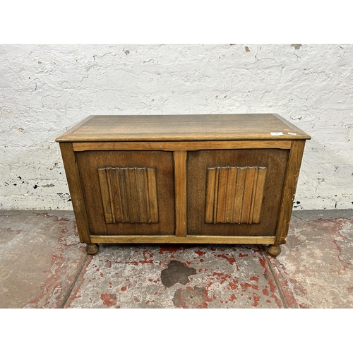 57 - A mid 20th century oak linenfold blanket box - approx. 52cm high x 82cm wide x 36cm deep