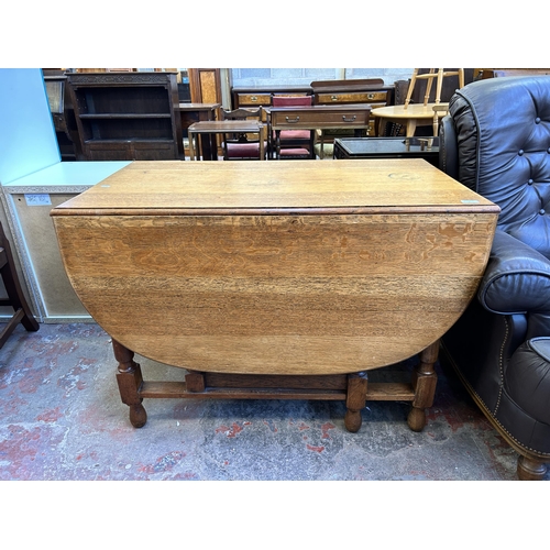 60A - An oak drop leaf gate leg dining table - approx. 76cm high x 106cm wide x 150cm long