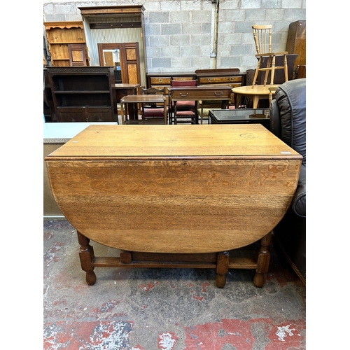 60A - An oak drop leaf gate leg dining table - approx. 76cm high x 106cm wide x 150cm long