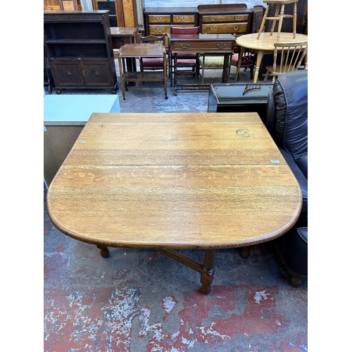 60A - An oak drop leaf gate leg dining table - approx. 76cm high x 106cm wide x 150cm long