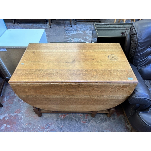 60A - An oak drop leaf gate leg dining table - approx. 76cm high x 106cm wide x 150cm long