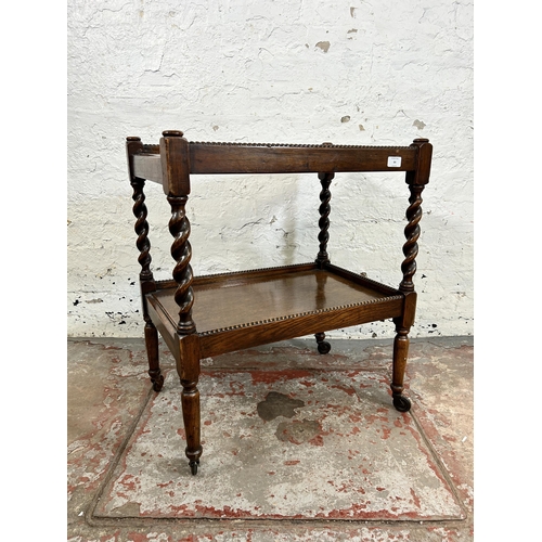 84 - An early 20th century oak two tier tea trolley with barley twist supports and beaded decoration - ap... 