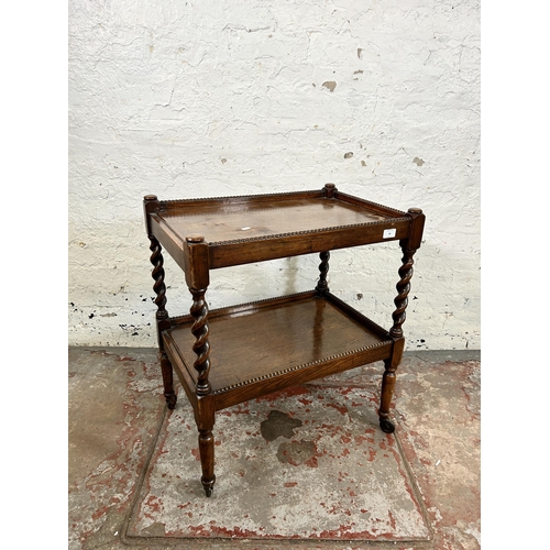 84 - An early 20th century oak two tier tea trolley with barley twist supports and beaded decoration - ap... 