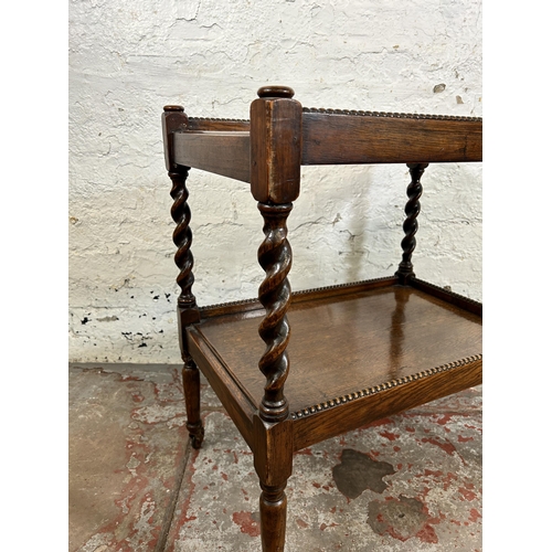 84 - An early 20th century oak two tier tea trolley with barley twist supports and beaded decoration - ap... 