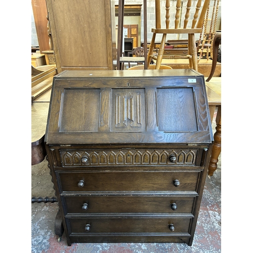 86 - A carved oak linenfold bureau - approx. 99cm high x 76cm wide x 46cm deep