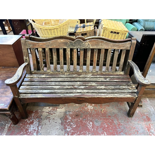 94 - A carved teak garden bench - approx. 89cm high x 115cm wide x 58cm deep