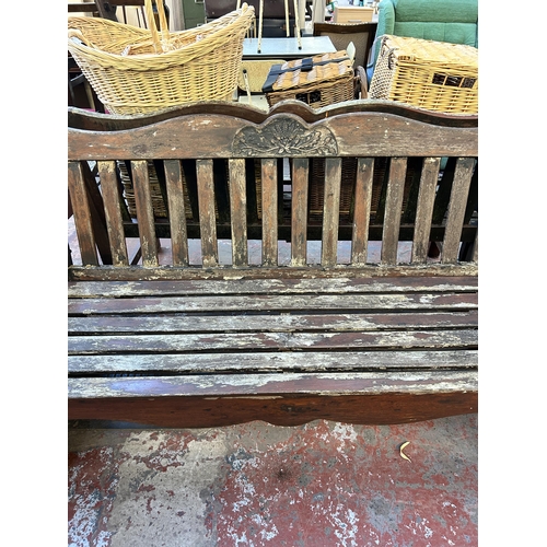 94 - A carved teak garden bench - approx. 89cm high x 115cm wide x 58cm deep