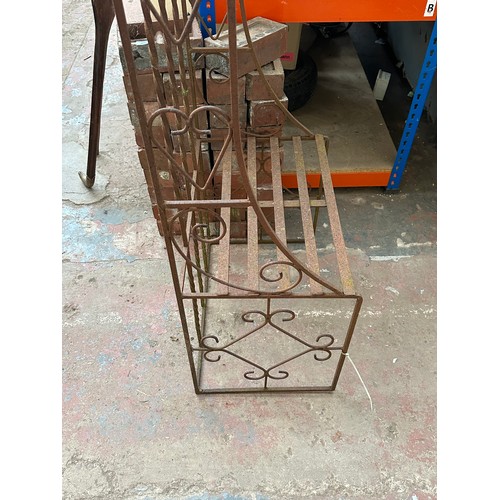 816 - A large wrought iron garden arch with opposing benches - approx. 257cm high x 205cm wide x 61cm deep