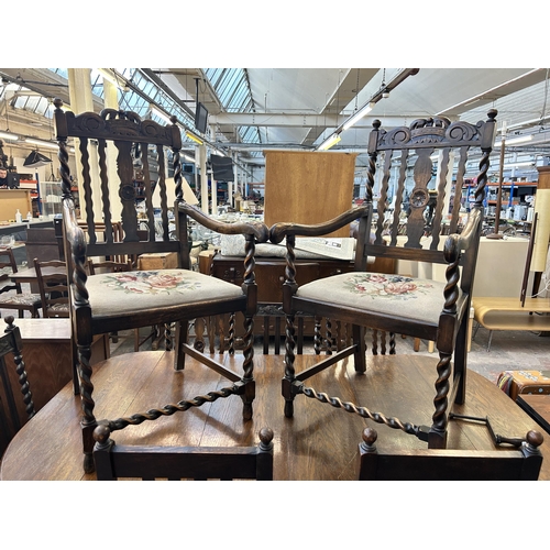 141 - An early 20th century oak wind out dining table and eight chairs with barley twist supports - approx... 