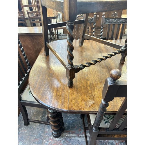 141 - An early 20th century oak wind out dining table and eight chairs with barley twist supports - approx... 