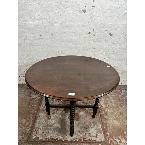 146 - An early 20th century oak tilt top occasional table on bobbin turned supports - approx. 61cm high x ... 