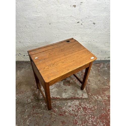 165 - A mid 20th century oak school desk - approx. 70cm high x 62cm wide x 46cm deep