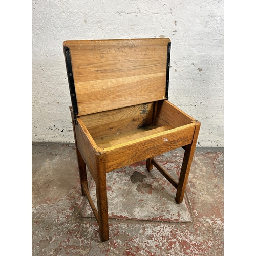 165 - A mid 20th century oak school desk - approx. 70cm high x 62cm wide x 46cm deep