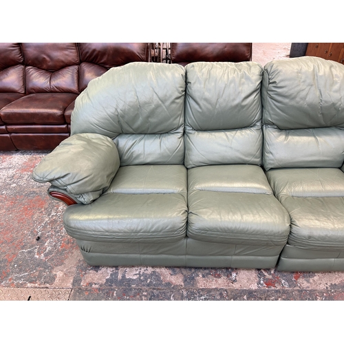 185 - A green leather three seater sofa