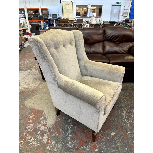 185A - A Laura Ashley silver fabric upholstered wingback armchair on turned mahogany supports - approx. 102... 