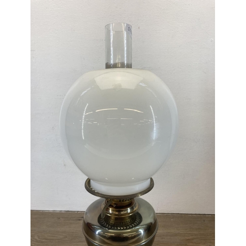 547 - A vintage brass oil lamp with opaline glass shade