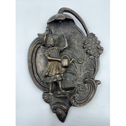 2369 - A bronzed cast metal figural wall plaque with floral decoration - approx. 32cm high