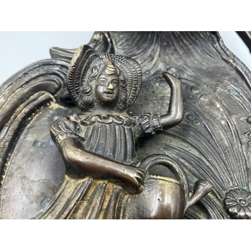 2369 - A bronzed cast metal figural wall plaque with floral decoration - approx. 32cm high