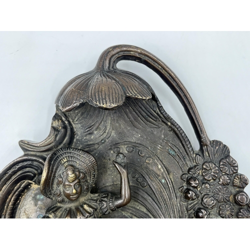 2369 - A bronzed cast metal figural wall plaque with floral decoration - approx. 32cm high