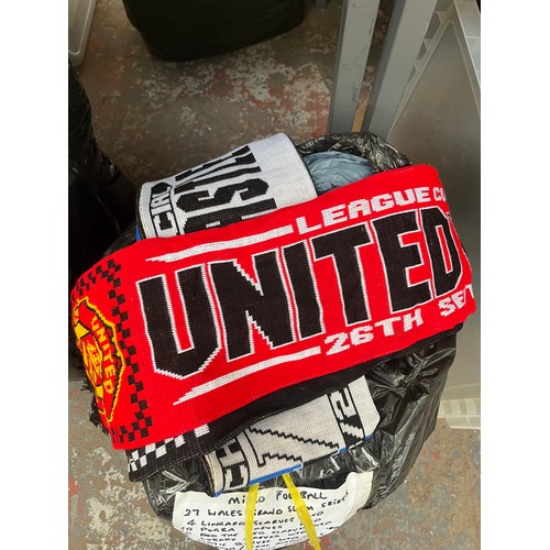 965 - Three bags containing a large quantity of sports scarves and t-shirts to include Liverpool, Wales vs... 