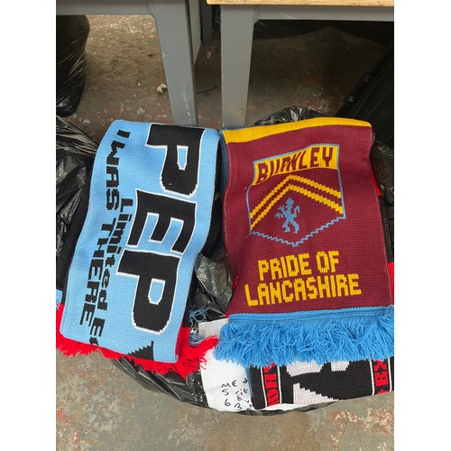 965A - Three bags containing a large quantity of sports scarves and t-shirts to include Huddersfield, Manch... 