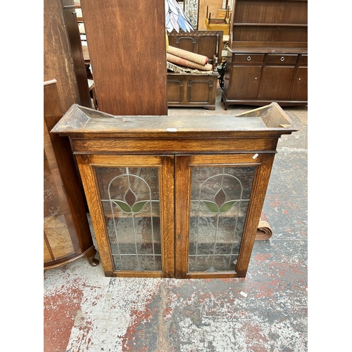 22A - An early 20th century oak bookcase with two leaded and stained glass doors - approx. 100cm high x 96... 