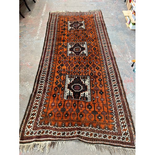 152 - A mid 20th century hand knotted orange rug - approx. 298cm long x 135cm wide