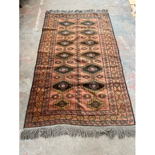 116 - A mid/late 20th century machine woven red rug - approx. 230cm long x 135cm wide