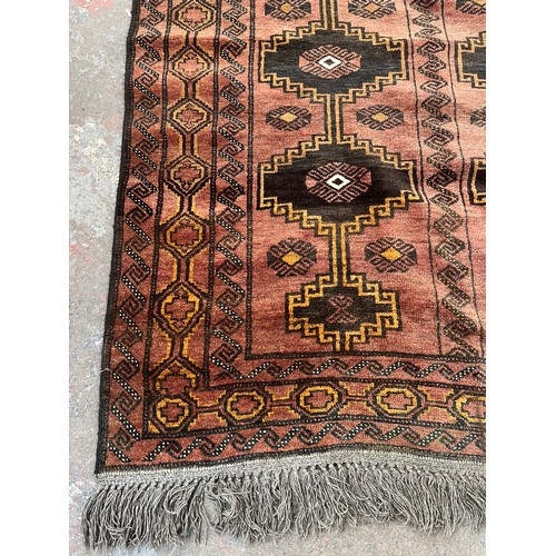 116 - A mid/late 20th century machine woven red rug - approx. 230cm long x 135cm wide