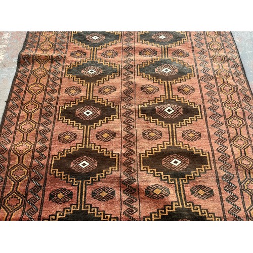 116 - A mid/late 20th century machine woven red rug - approx. 230cm long x 135cm wide