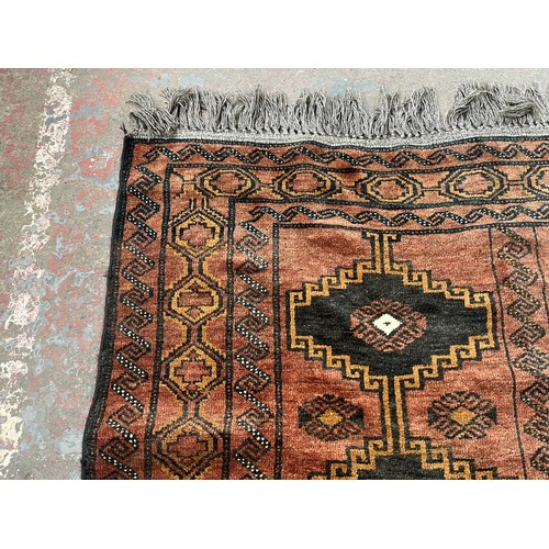 116 - A mid/late 20th century machine woven red rug - approx. 230cm long x 135cm wide