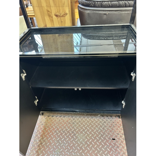 49 - A Pierre Vandel of Paris black lacquered metal and glass top two tier open shelving unit with two lo... 