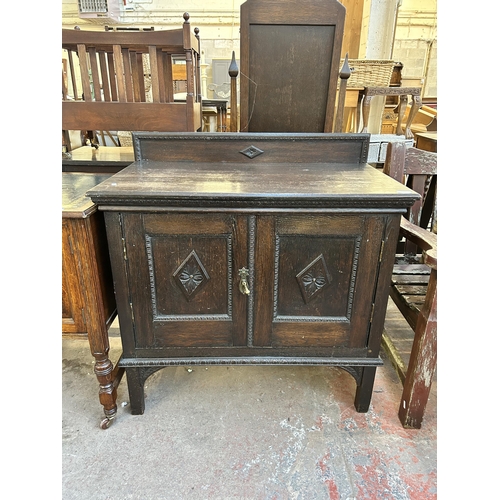 122 - An early 20th century carved oak two door cabinet with fitted interior - approx. 93cm high x 91cm wi... 