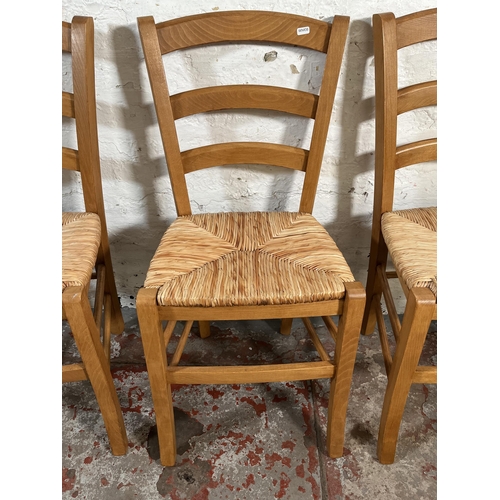 102 - Four beech and rush seated dining chairs