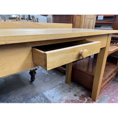 131 - A modern oak writing desk - approx. 82cm high x 122cm wide x 56cm deep